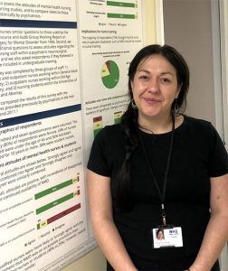Picture of Rhiannon Buick standing in front of poster at conference